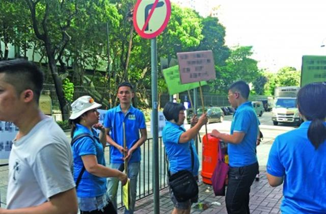 Members of the “Knowledge Is Power” group holding placards before the Macpherson Stadium to oppise the dance competition. (Epoch Times)