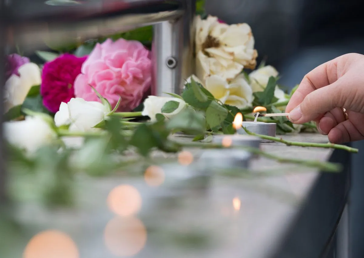 Candles are lit near a mall where a shooting took place leaving nine people dead in Munich, Germany, on July 23, 2016. (AP Photo/Sebastian Widmann)