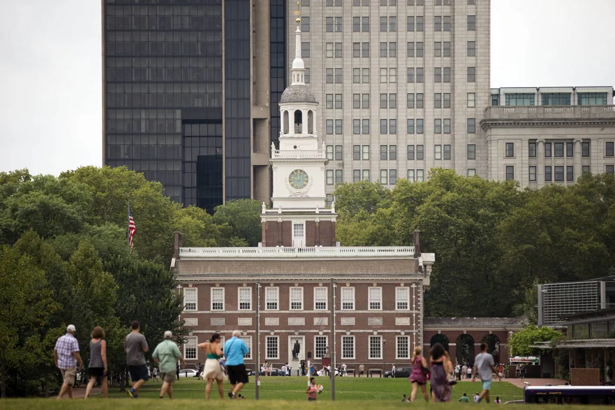 Cisitors walk in view of Independence Hall in Philadelphia on July 30, 2015. Democrats are set to begin their convention Monday, July 25, 2016 in a city that symbolizes both the nation's promise and its shortcomings. (AP Photo/Matt Rourke)