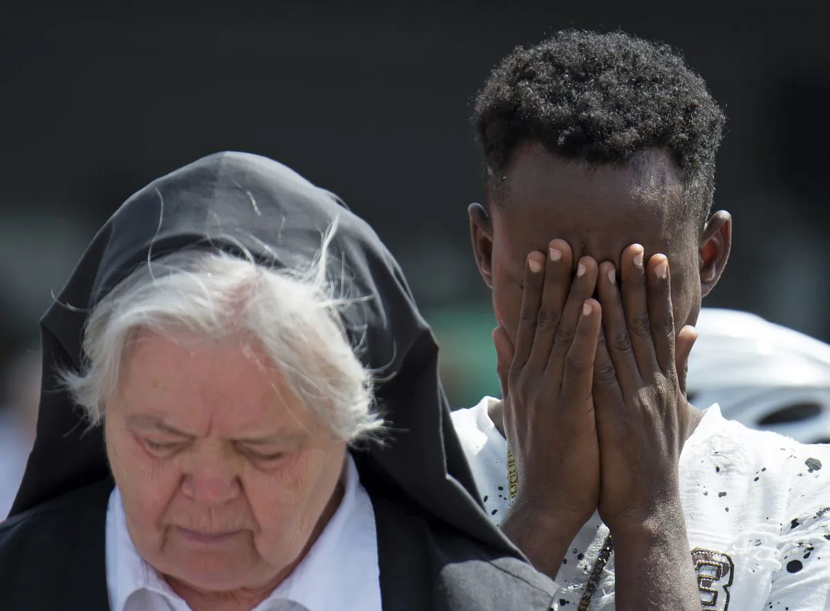 People mourn beside the Olympia shopping center where a shooting took place leaving nine people dead two days ago in Munich, Germany, on July 24, 2016. (AP Photo/Jens Meyer)