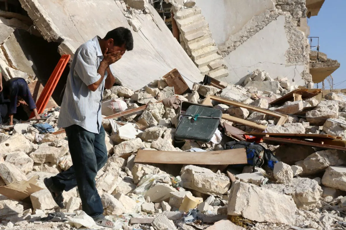 A Syrian man reacts as rescuers look for victims under the rubble of a collapsed building following a reported airstrike on the rebel-held neighborhood of Sakhur in the northern city of Aleppo on July 19, 2016. (Thaer Mohammed/AFP/Getty Images)