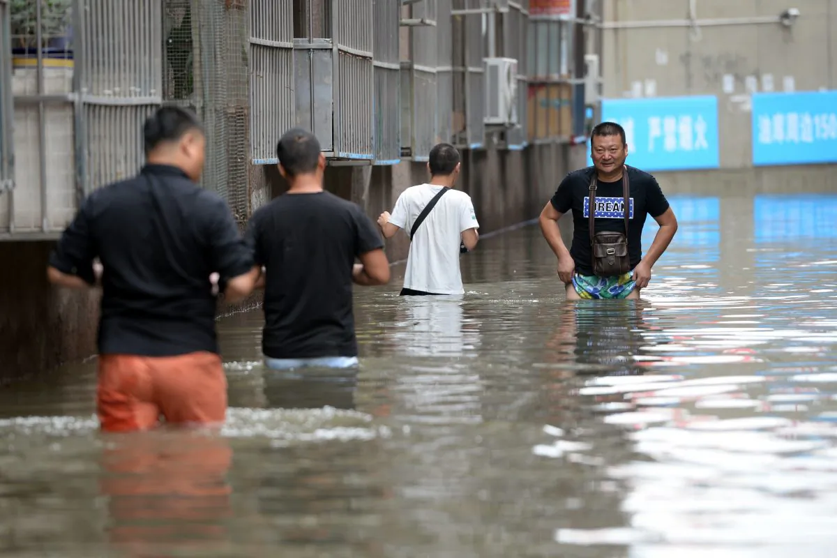 People making their way through a flooded area in Changping District in Beijing.
Torrential rain lashing northern China in recent days has left 130 people dead in a province near Beijing. (STR/AFP/Getty Images)