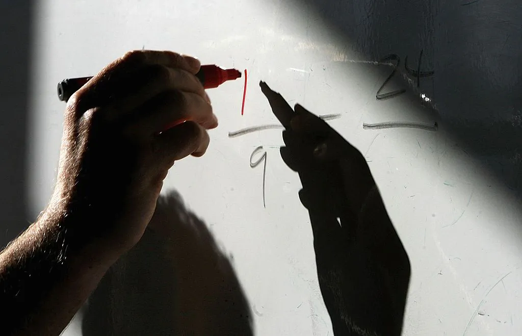 A math teacher writes on a white board in in this file photo. (Christopher Furlong/Getty Images)