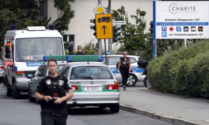 A police officer walks in front of the Benjamin-Franklin Hospital in the southwestern district of Steglitz in Berlin, Germany, Tuesday, July 26, 2016. German police say a patient has apparently shot at a doctor and killed himself at a hospital in Berlin. (AP Photo/Michael Sohn)