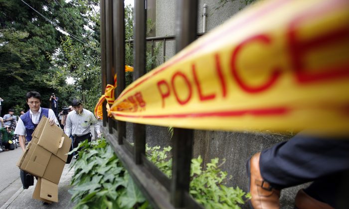 Police officers enter into the house of Satoshi Uematsu, the suspect in a mass stabbing attack, in Sagamihara, outside of Tokyo, Wednesday, July 27, 2016. The suspect was being transferred Wednesday from a local police station to the prosecutor's office in Yokohama. (AP Photo/Shizuo Kambayashi)