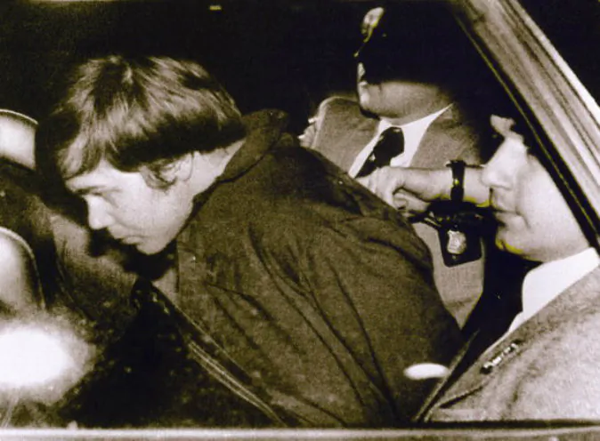 John Hinckley Jr. (L) escorted by police in Washington, DC, following his arrest after shooting and seriously wounding then-US president Ronald Reagan. A U.S. District judge ruled on July 27 that Hinckley no longer poses any danger to himself or others. (AFP/AFP/Getty Images)