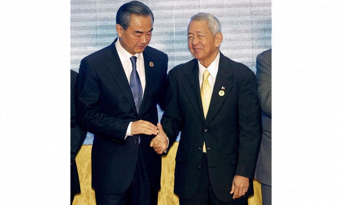 China's Foreign Minister Wang Yi (L) stands with Philippines Foreign Minister Perfecto Yasay Jr. during the Association of Southeast Asian Nations (ASEAN) Foreign Ministers' Meeting in Vientiane, Laos, on July 26, 2016. A recent ruling in a territorial dispute in the South China Sea favoured the Philippines, angering Beijing. (AP photo/Sakchai Lalit)