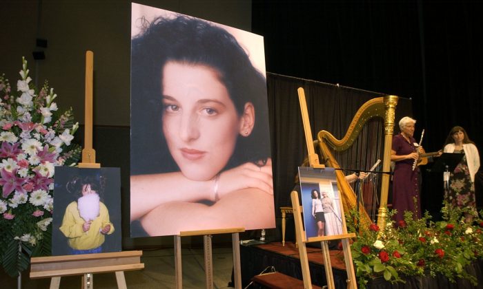 Photos of Chandra Levy are on display as musicians (R) stand by at the memorial service for Levy on May 28, 2002. (AP Photo/Debbie Noda)