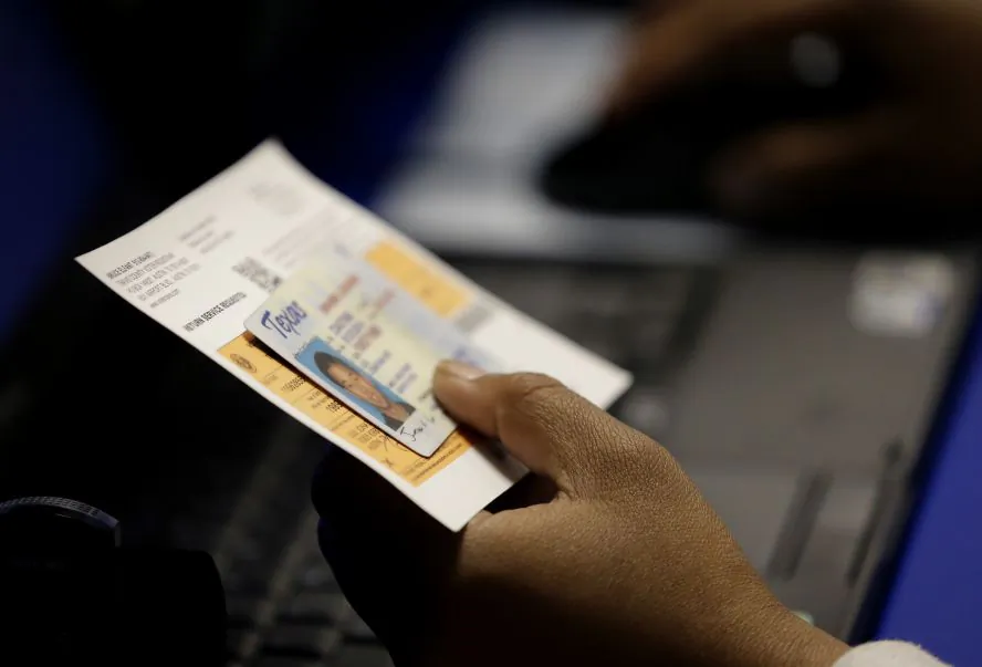 An official checks a voter's photo identification at an early voting polling site in Austin, Texas, on Feb. 26, 2014. (Eric Gay/AP Photo)