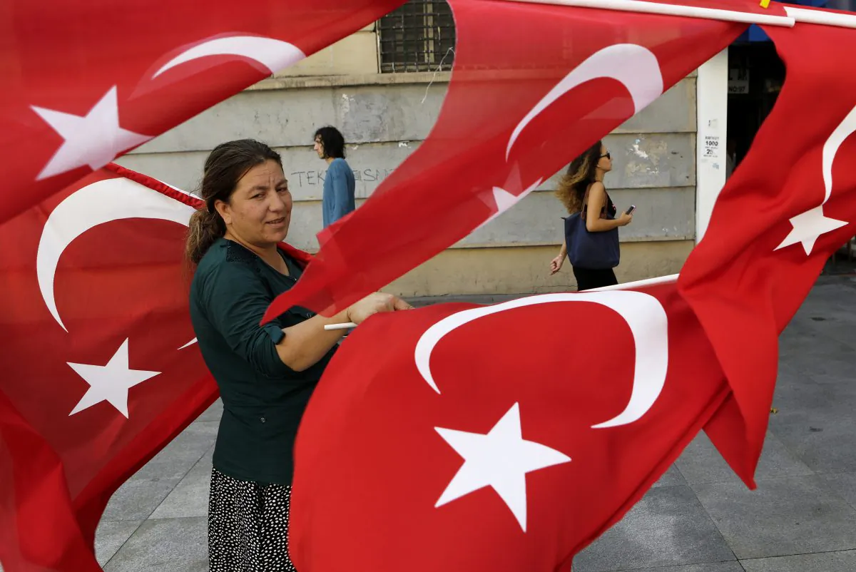 A woman sells Turkish flags in Istanbul, on July 30, 2016. (AP Photo/Petros Karadjias)