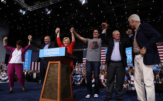 (L-R) Anne Holton, democratic vice presidential nominee U.S. Sen Tim Kaine (D-VA), democratic presidential nominee former Secretary of State Hillary Clinton, Mark Cuban, U.S. Rep. Mike Doyle (D-PA) and former U.S. president Bill Clinton raise arms during a campaign rally  at the David L. Lawrence Convention Center on July 30, 2016 in Pittsburgh, Pennsylvania. (Photo by Justin Sullivan/Getty Images)