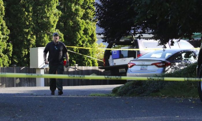 An investigator works at the scene of a multiple murder in the Chenault Beach neighborhood of Mukilteo, Wash., Saturday July 30, 2016.  A suspect was apprehended three counties away, said Officer Myron Travis of the Mukilteo Police Department. (Alan Berner/The Seattle Times via AP)