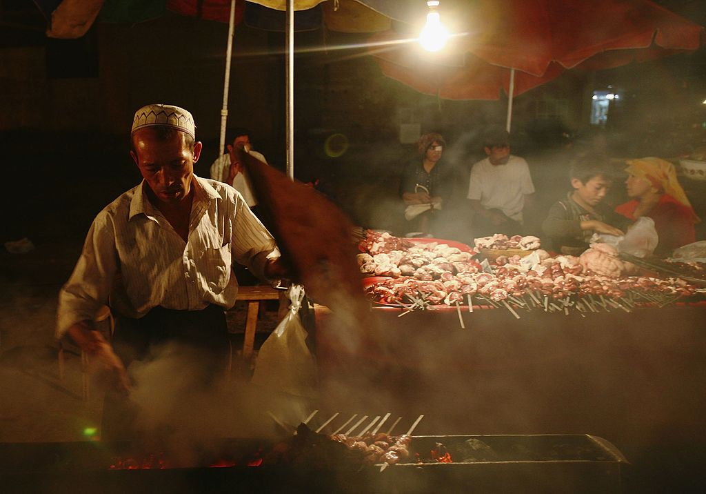 A vendor makes shashlik (kebab) at a booth in Kashi of Xinjiang Uygur Autonomous Region, 
on Sept. 20, 2006 (China Photos/Getty Images)