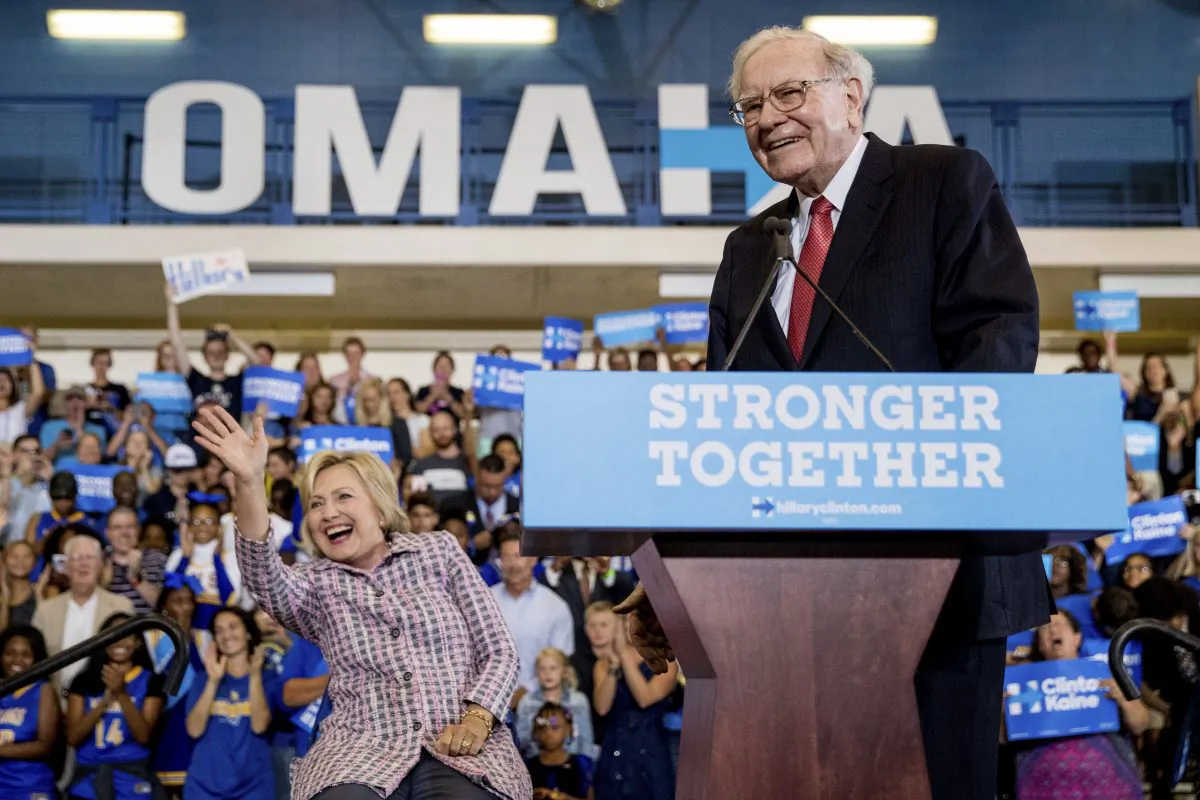 Democratic presidential candidate Hillary Clinton, left, waves to audience members as she and Berkshire Hathaway CEO Warren Buffett, right, arrive at a rally at Omaha North High Magnet School in Omaha, Neb.,on Aug. 1, 2016. (AP Photo/Andrew Harnik)