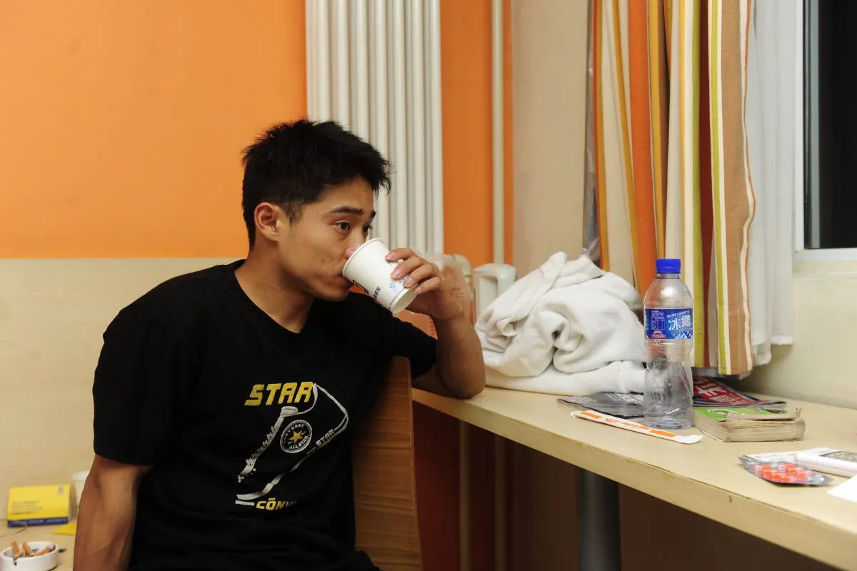 Zhang Shangwu has a drink after an interview at a hotel room in Beijing on July 18, 2011. The champion gymnast forced to turn to begging after injury ended his career prematurely due to an injury. He became a media sensation in China after a fan recognized him eking out a living on the streets of Beijing. Zhang's case throws the spotlight on the plight of top athletes in China, who are taken from their homes as young as five only then to be abandoned and forgotten when they are no longer able to compete. (STR/AFP/Getty Images)