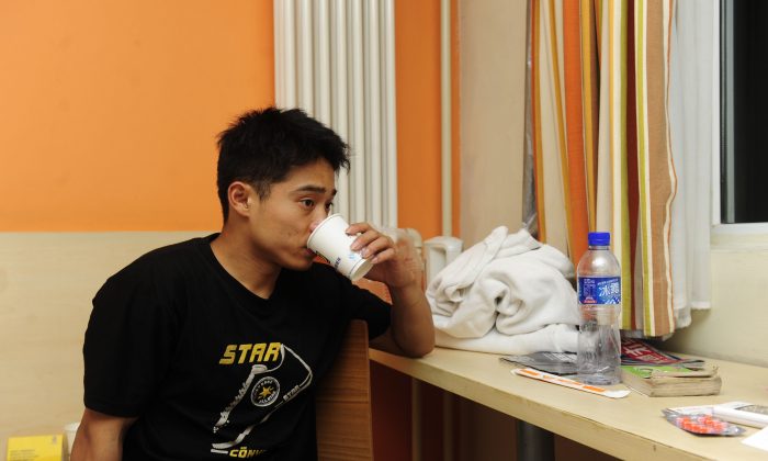 Zhang Shangwu has a drink after an interview at a hotel room in Beijing on July 18, 2011. The champion gymnast forced to turn to begging after injury ended his career prematurely due to an injury. He became a media sensation in China after a fan recognized him eking out a living on the streets of Beijing. Zhang's case throws the spotlight on the plight of top athletes in China, who are taken from their homes as young as five only then to be abandoned and forgotten when they are no longer able to compete. (STR/AFP/Getty Images)