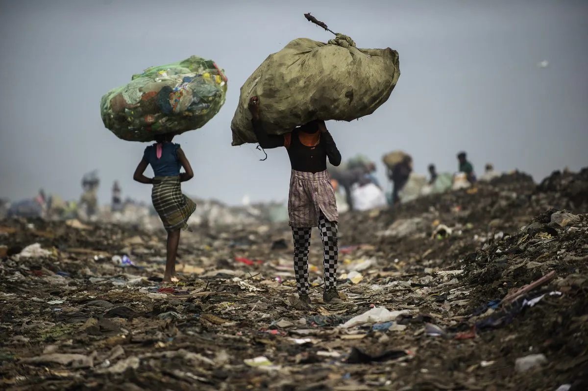 Girls carry bags of plastic items and tins as rubbish pickers sift through garbage at the Maputo municipal garbage dumping site in Maputo, Mozambique, on Oct. 14, 2014. (Gianluigi Guercia/AFP/Getty Images)