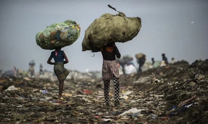 Girls carry bags of plastic items and tins as rubbish pickers sift through garbage at the Maputo municipal garbage dumping site in Maputo, Mozambique, on Oct. 14, 2014. (Gianluigi Guercia/AFP/Getty Images)