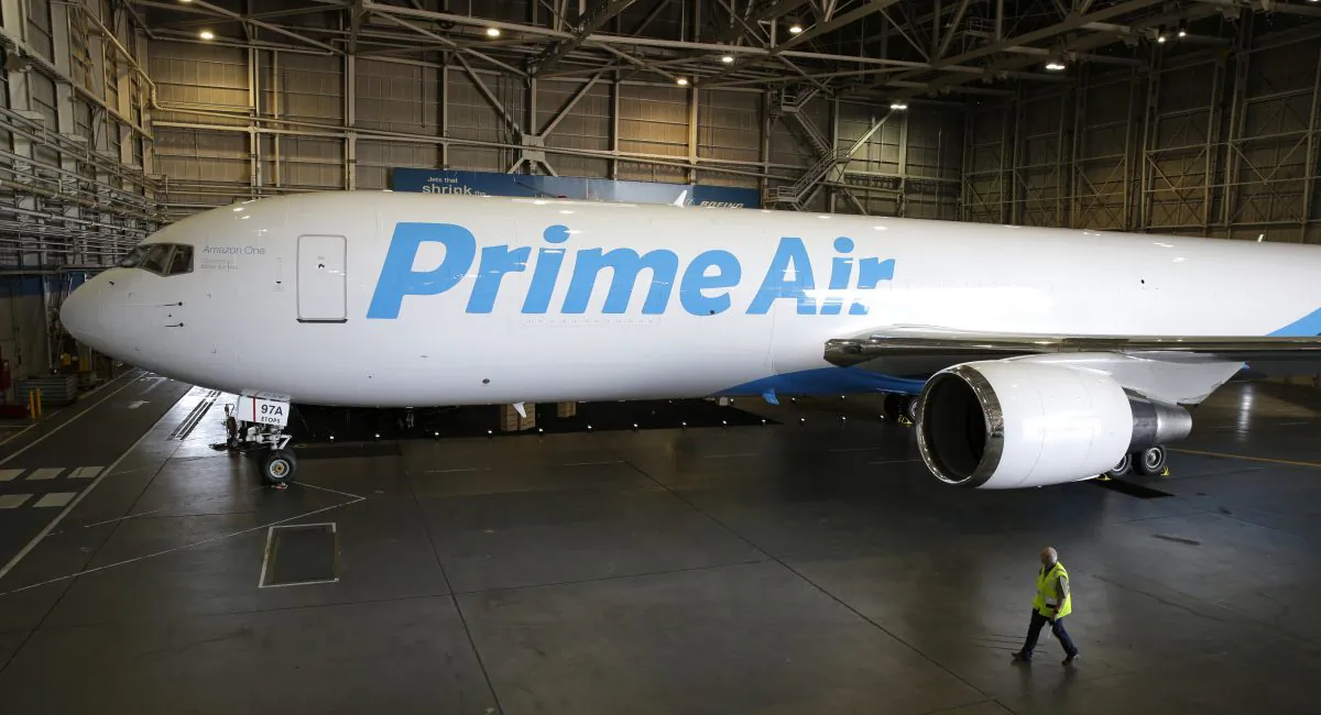 A worker walks past a Boeing 767 with an Amazon.com "Prime Air" livery on display Thursday, Aug. 4, 2016, in a Boeing hangar in Seattle. Amazon unveiled its first branded cargo plane Thursday, one of 40 jetliners that will make up Amazon's own air transportation network of 40 Boeing jets leased from Atlas Air Worldwide Holdings and Air Transport Services Group Inc., which will operate the air cargo network. (AP Photo/Ted S. Warren)