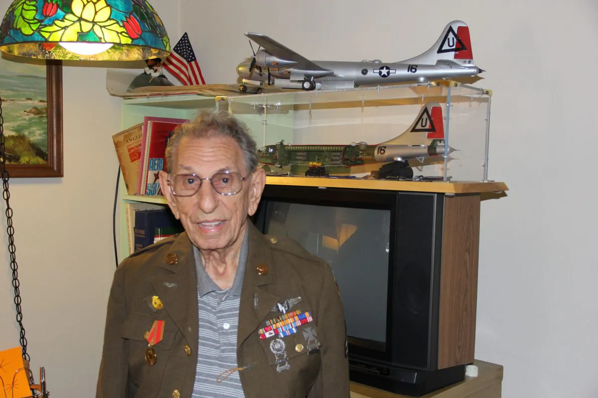 George Allen at his home in San Jose in front of a replica of a B-29 bomber where he was a tail gunner during WWII (Steve Ispas/Epoch Times)