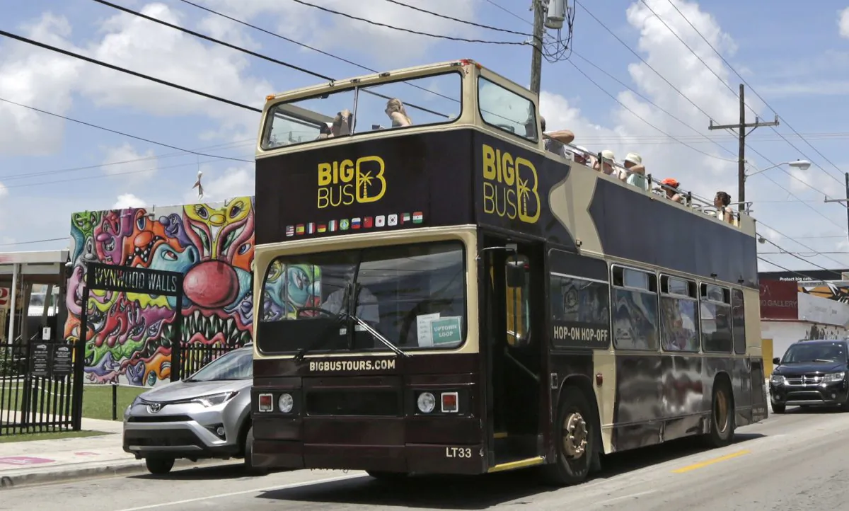 A tour bus makes a stop in front of the Wynwood Walls in the Wynwood area of Miami on Aug. 5, 2016. (AP Photo/Alan Diaz)
