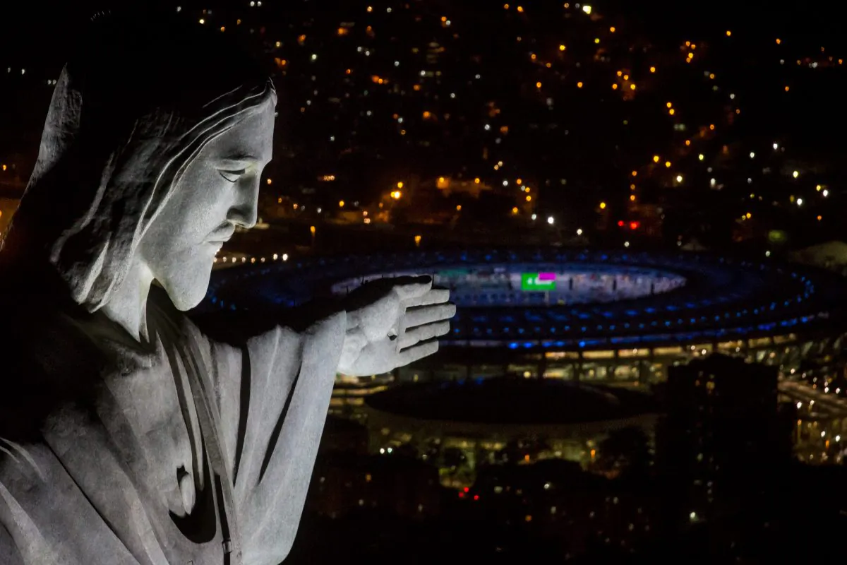 The Christ the Redeemer statue is seen at sunset in front of the Maracana Stadium ahead of the 2016 Summer Olympic Games in Rio de Janeiro, Brazil, on July 31, 2016. (Chris McGrath/Getty Images)