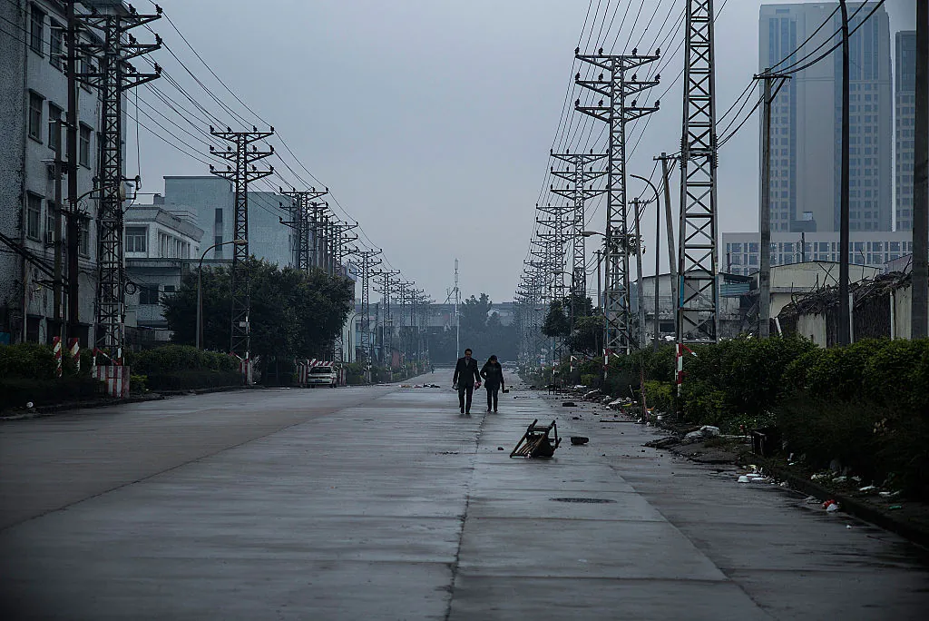 A couple walks on a street at an abandoned industrial area of Houjie town in Donggyuan on Jan. 27, 2016. (Lam Yik Fei/Getty Images)