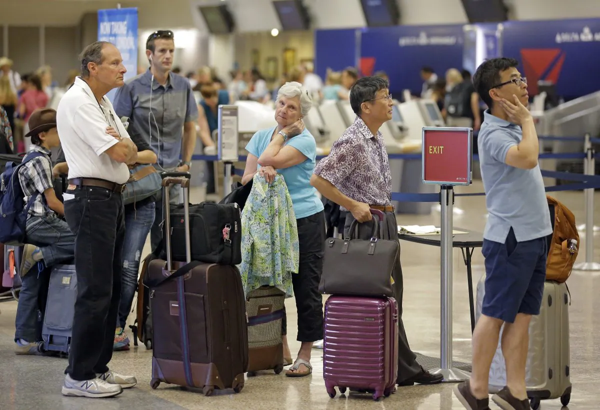 Delta passengers stand in line as the carrier slogged through day two of its recovery from a global computer outage in Salt Lake City on Aug. 9, 2016. (AP Photo/Rick Bowmer)