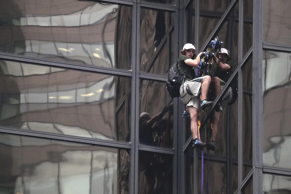 A man scales the all-glass facade of Trump Tower using suction cups Wednesday, Aug. 10, 2016, in New York. A police spokeswoman says officers responded to Donald Trump's namesake skyscraper on Fifth Avenue in Manhattan. The 58-story building is headquarters to the Republican presidential nominee's campaign. He also lives there. (AP Photo/Julie Jacobson)