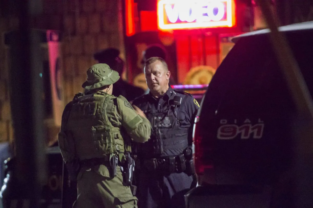 Police confer outside of a house in Strathroy, Ontario, Wednesday, August 10, 2016. A suspect is dead after Canada's national police force thwarted what an official said was a suicide bomb plot. (Geoff Robins/The Canadian Press via AP)