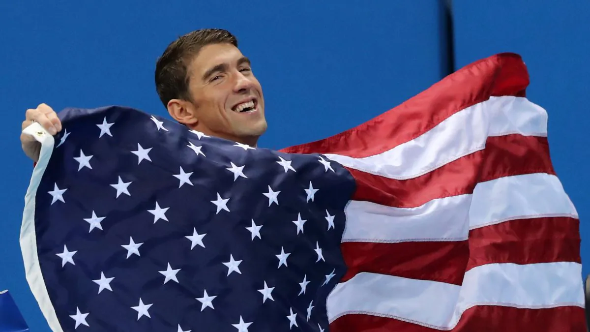 United States' Michael Phelps walks with his national flag during the medal ceremony for the men's 4 x 100-meter medley relay final during the swimming competitions at the 2016 Summer Olympics in Rio de Janeiro, Brazil, on Aug. 14, 2016. (AP Photo/Lee Jin-man)