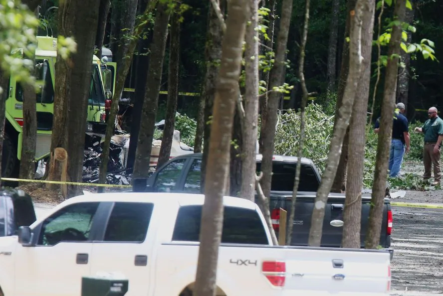 Authorities work the scene of a plane crash at a park along Robert Cardinal Airport Road across from the Tuscaloosa Regional Airport in Northport, Ala., Sunday, Aug. 14, 2016. Authorities said several people are dead following the crash of a small airplane near Tuscaloosa, Alabama. (Erin Nelson/The Tuscaloosa News via AP)
