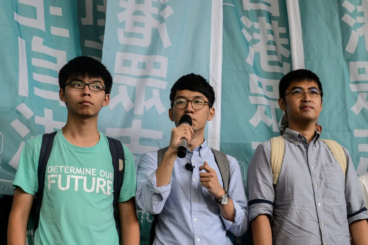 (L to R) Joshua Wong, 19, Nathan Law, 23, and Alex Chow, 25, student leaders of Hong Kong's Umbrella Movement, speak to the press following their sentencing at the Eastern Court in Hong Kong on August 15, 2016.
(Anthony Wallace/AFP/Getty Images)