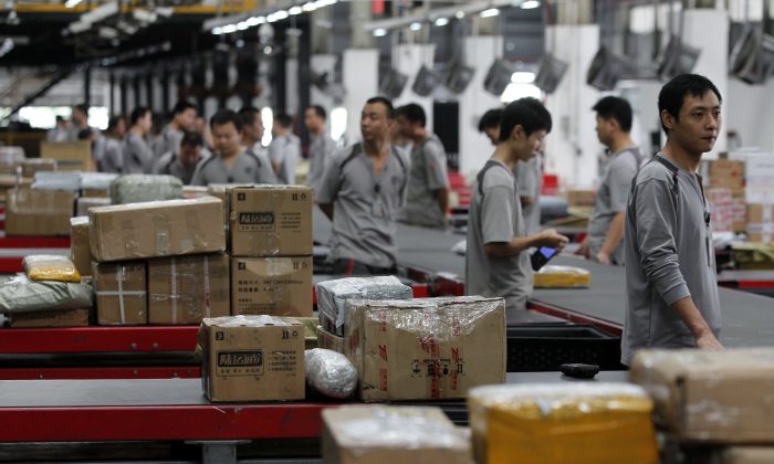 2013 年 11 月 11 日，工人在中国深圳顺丰快递配送包裹。（ChinaFotoPress/ChinaFotoPress via Getty Images）