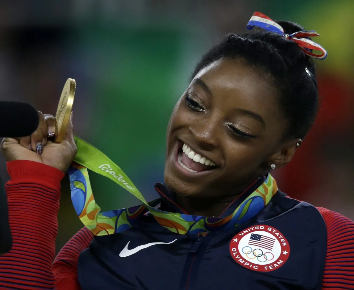 Simone Biles displays her gold medal for floor during the artistic gymnastics women's apparatus final at the 2016 Summer Olympics. (AP Photo/Rebecca Blackwell)