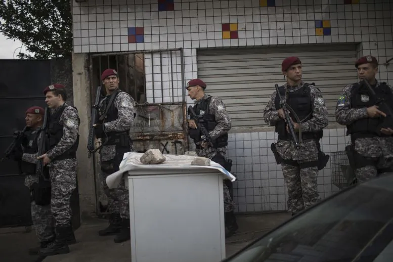 Brazil's national security force officers move inside the Vila do Joao, part of the Mare complex of slums, during a police operation in search for criminals during the 2016 Summer Olympics in Rio de Janeiro, Brazil, Thursday, Aug. 11, 2016. A police officer has died after being shot in the head when he and two others working security at the Rio Olympics got lost near a slum and encountered gunfire. (AP Photo/Felipe Dana)