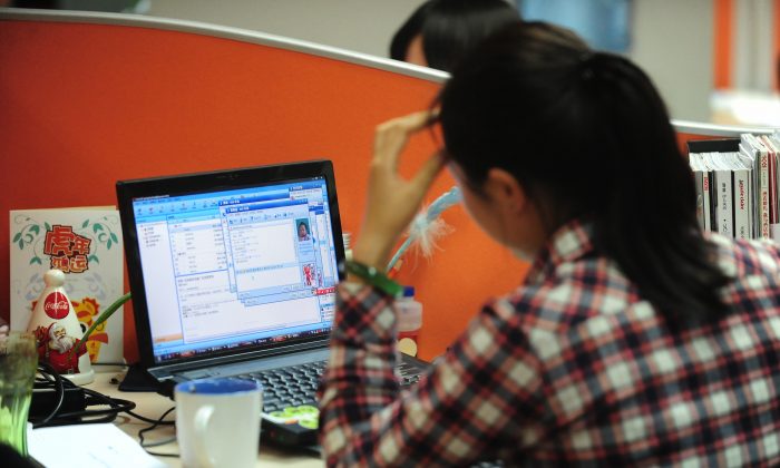 A woman works online in her cubicle at an office in Beijing on February 4, 2010.   (Frederic J. Brown/AFP/Getty Images)
