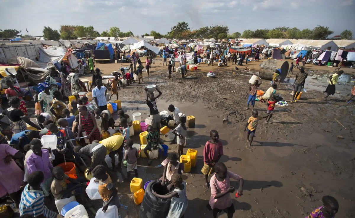 Displaced people gather around a water truck to fill containers at a United Nations compound which has become home to thousands of people displaced by the recent fighting, in the capital Juba, South Sudan, on Dec. 29 2013. (AP Photo/Ben Curtis)