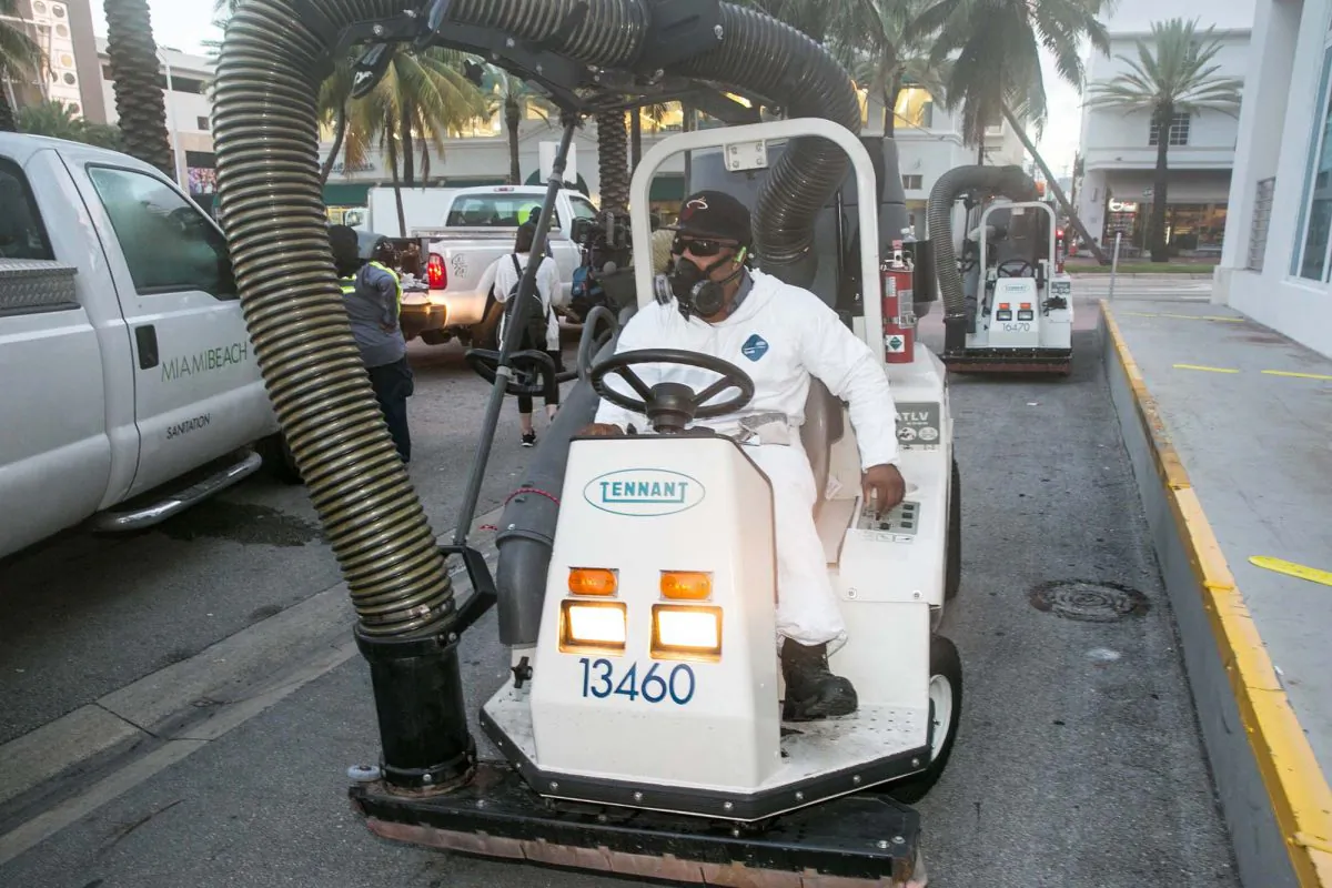 A City of Miami Beach Sanitation worker gets ready to clean the alleyways of South Beach, sucking up still waters and debris with a mobile vacuum as part of the city's Zika clean-up, in Miami Beach, Fla., Aug. 19, 2016. (C.M. Guerrero/El Nuevo Herald via AP)