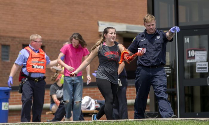 An emergency worker directs a volunteer with simulated injuries during a training exercise for an active shooter at Hopewell Elementary School, in West Chester, Ohio, on May 25, 2016. (AP Photo/John Minchillo)