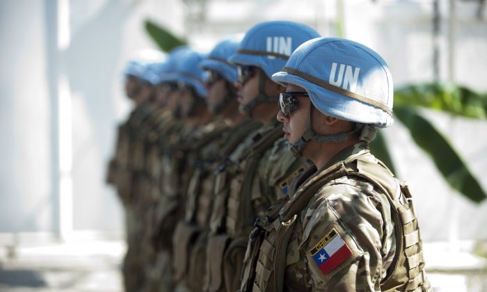 Chile's Army, part of the U.N. Stabilization Mission in Haiti (MINUSTAH) give honors to Cristian Barros, U.N. Security Council (UNSC) president, during the visit of the representatives of 15 Member States of the UNSC to the facilities of the Cuartel Carrera of Batallion Chile, in Cap-Haitien, on Jan. 24, 2015. (Hector Retamal/AFP/Getty Images)