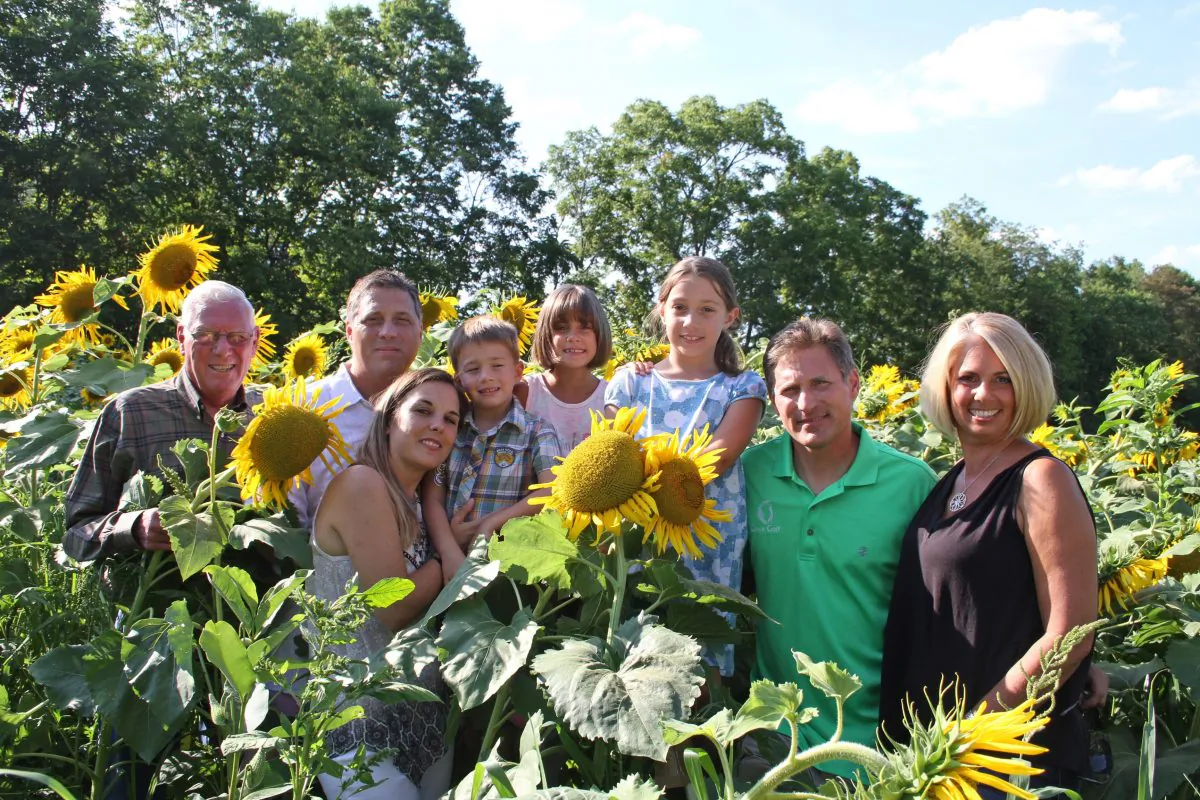 (L–R) John Haight, Jeff Haight and his wife Allison Haight; children Colin,
Delaney, and Claudia; Kevin Haight, and his wife Traci Simonton at the sunflower field in La Grange, New York in August. (Michelle Sottile)