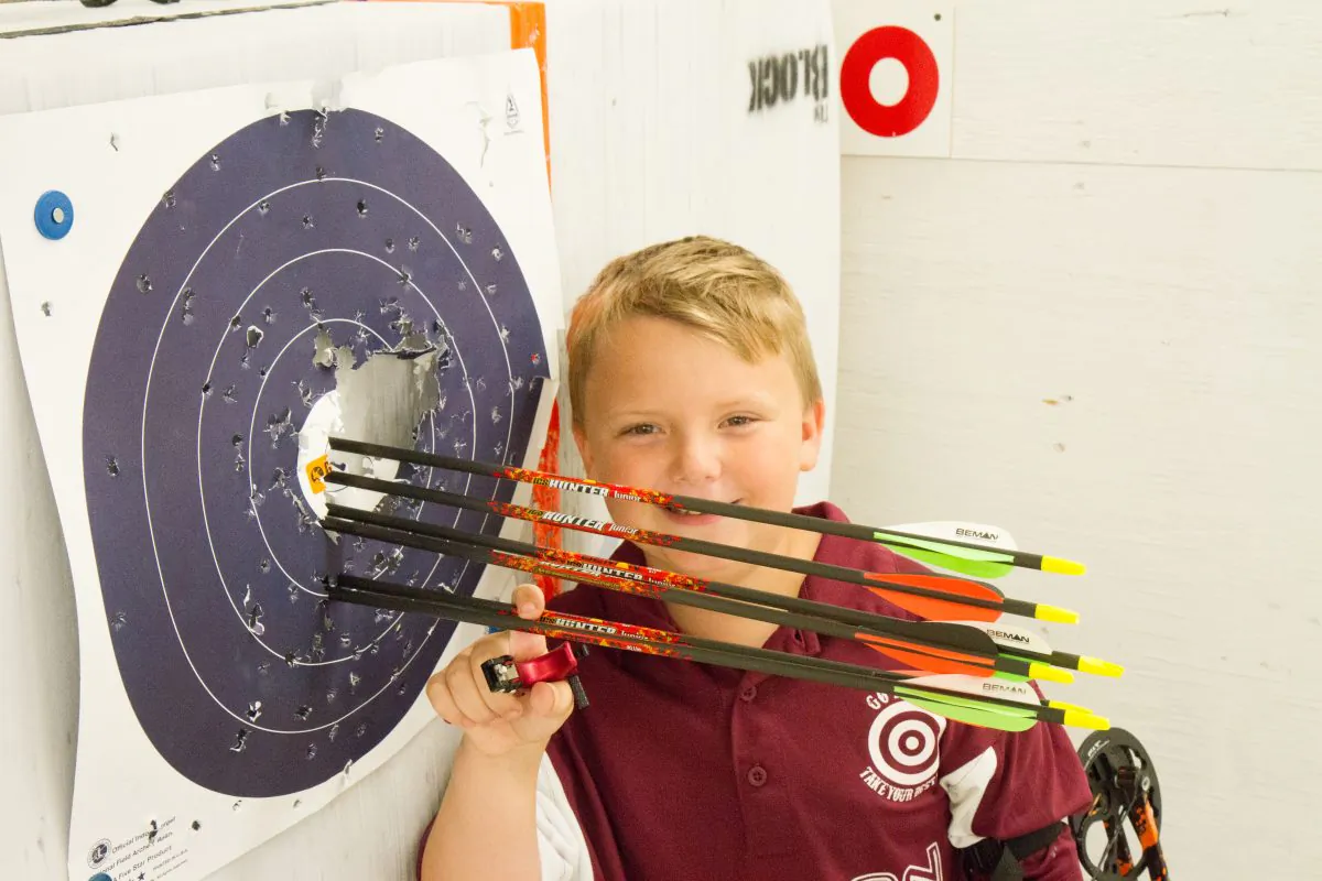 Jeffrey Paes, 8, stands next to six arrows he shot from 10 yards away during archery practice at Gander Mountain in the Town of Wallkill, N.Y., on Aug. 19, 2016. (Holly Kellum/Epoch Times)