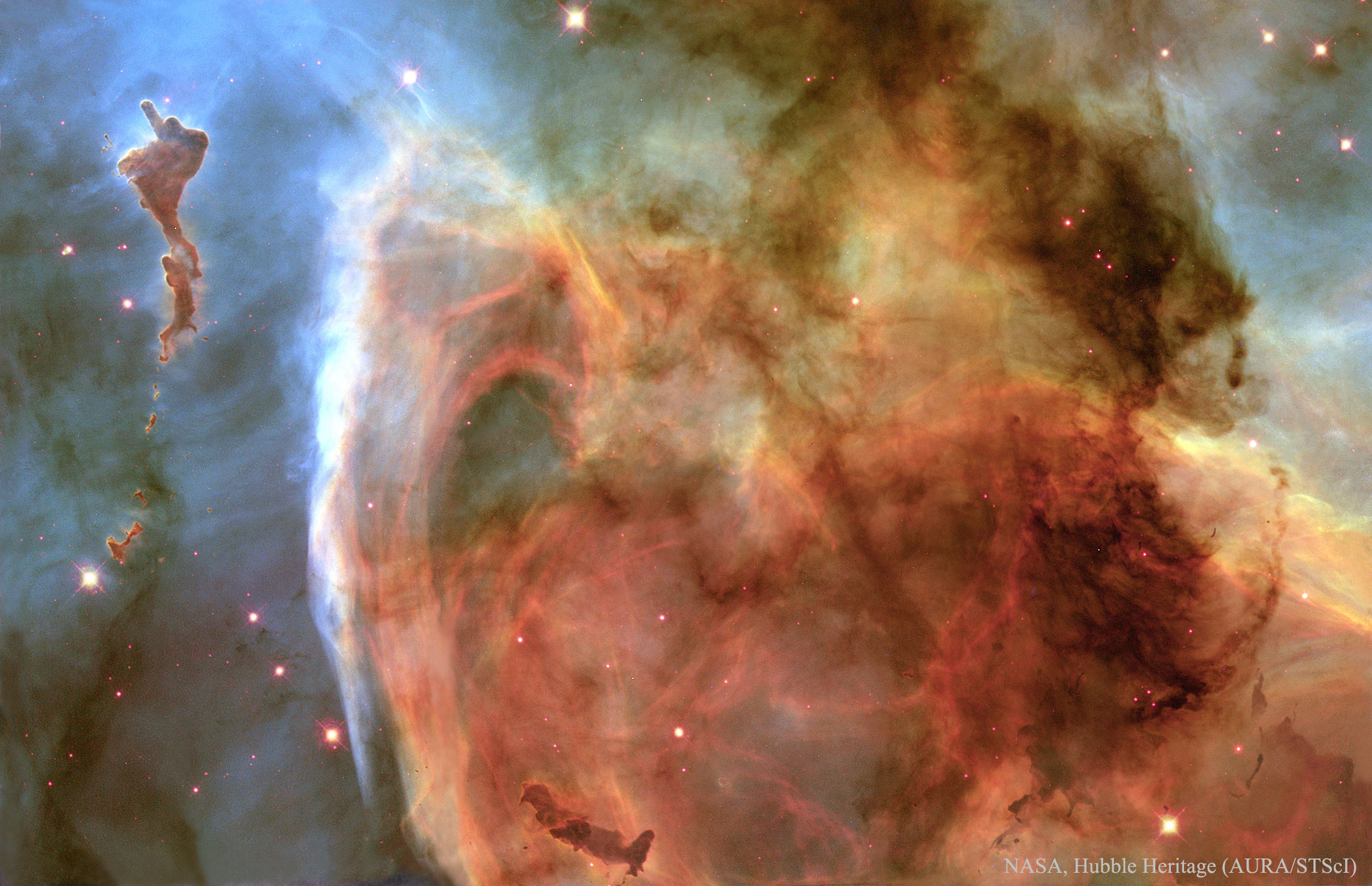 The dark dusty Keyhole Nebula gets its name from its unusual shape. The looping Keyhole, in this featured classic image by the Hubble Space Telescope, is a smaller region inside the larger Carina Nebula. Dramatic dark dust knots and complex features are sculpted by the winds and radiation of the Carina Nebula's many massive and energetic stars. The region lies about 7,500 light-years away. The Keyhole Nebula was created by the dying star Eta Carina, out of the frame, which is prone to violent outbursts during its final centuries. (NASA, Hubble Heritage/AURA/STScI)