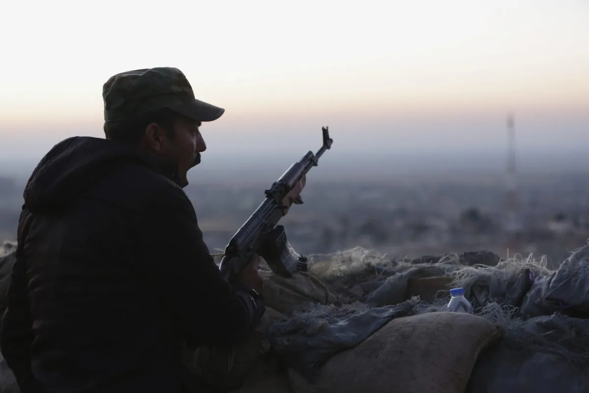A Kurdish fighter, known as a peshmerga, yawns as he stands guard on the frontline in Sinjar, Iraq, on Nov. 13, 2015. (AP Photo/Bram Janssen)