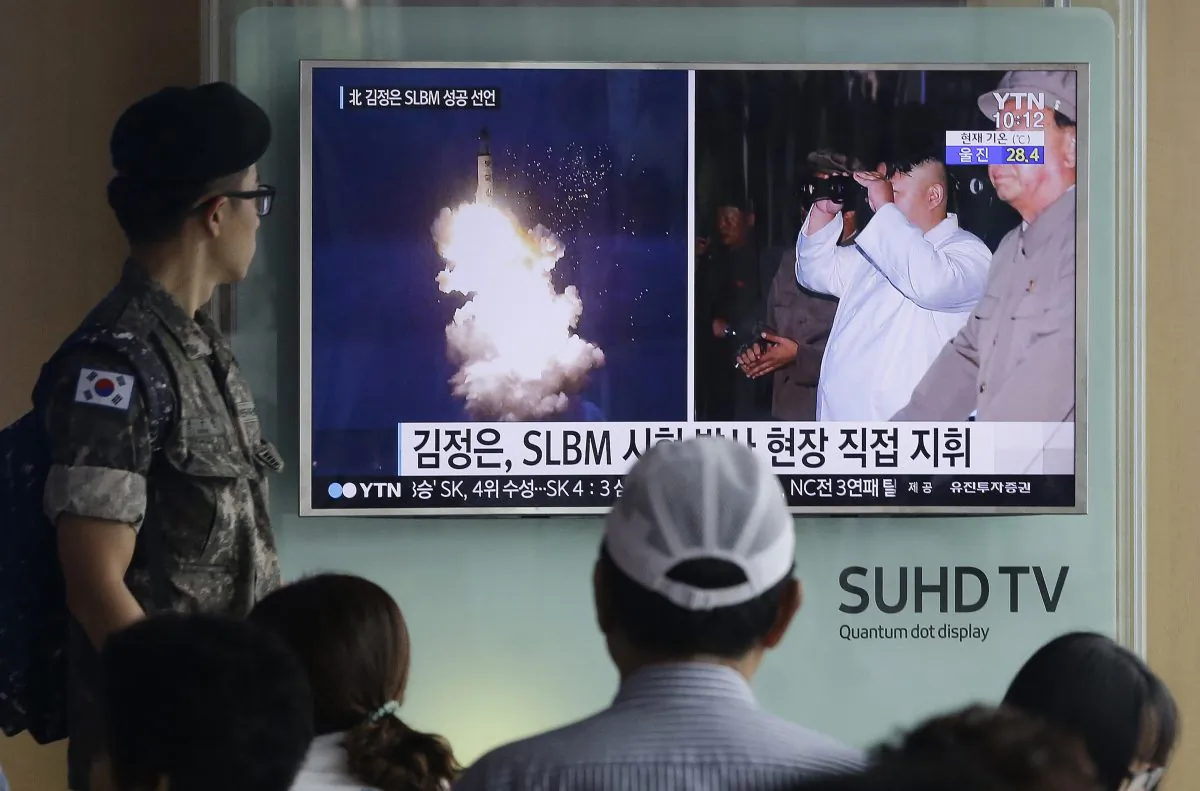 A South Korean Army soldier watches a TV news program showing images published in North Korea's Rodong Sinmun newspaper of North Korea's ballistic missile believed to have been launched from underwater and North Korean leader Kim Jong-un, at Seoul Railway station in Seoul, South Korea, on Aug. 25, 2016. (AP Photo/Ahn Young-joon)