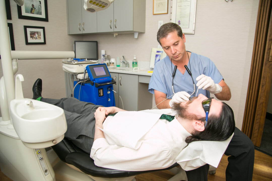 Dr. Chris Chondrogiannis with a patient at Madison Avenue Periodontics in Manhattan, N.Y. (Samira Bouaou/Epoch Times)