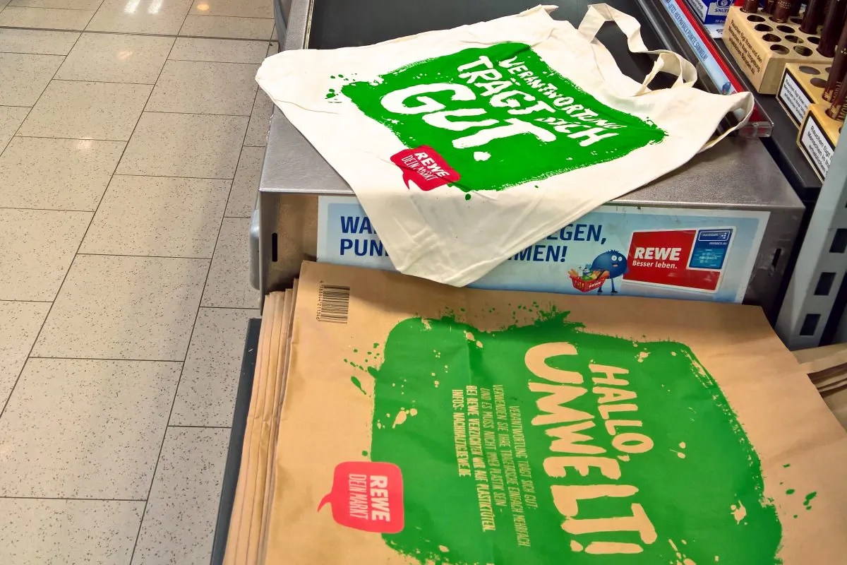 Cotton and paper shopping bags in REWE supermarket in Germany.   The bags read "Hello Environment“ in German. (Ilya Rzhevskiy/Epoch Times)