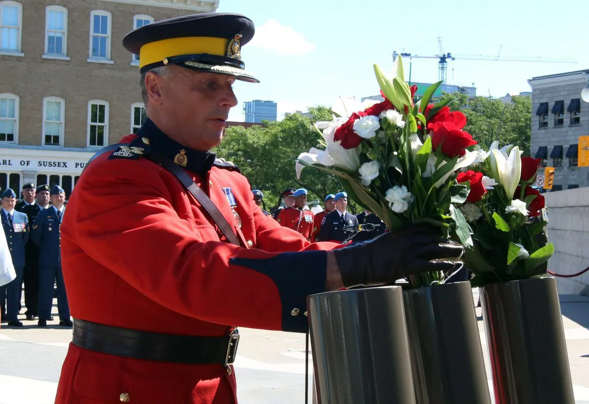 RCMP Assistant Commissioner Todd Shean places flowers during the National Peacekeepers' Day ceremony in Ottawa on Aug. 9, 2015. Ottawa is sending a reconnaissance mission to take a closer look at the U.N. peacekeeping operations in Mali. (The Canadian Press/Fred Chartrand)