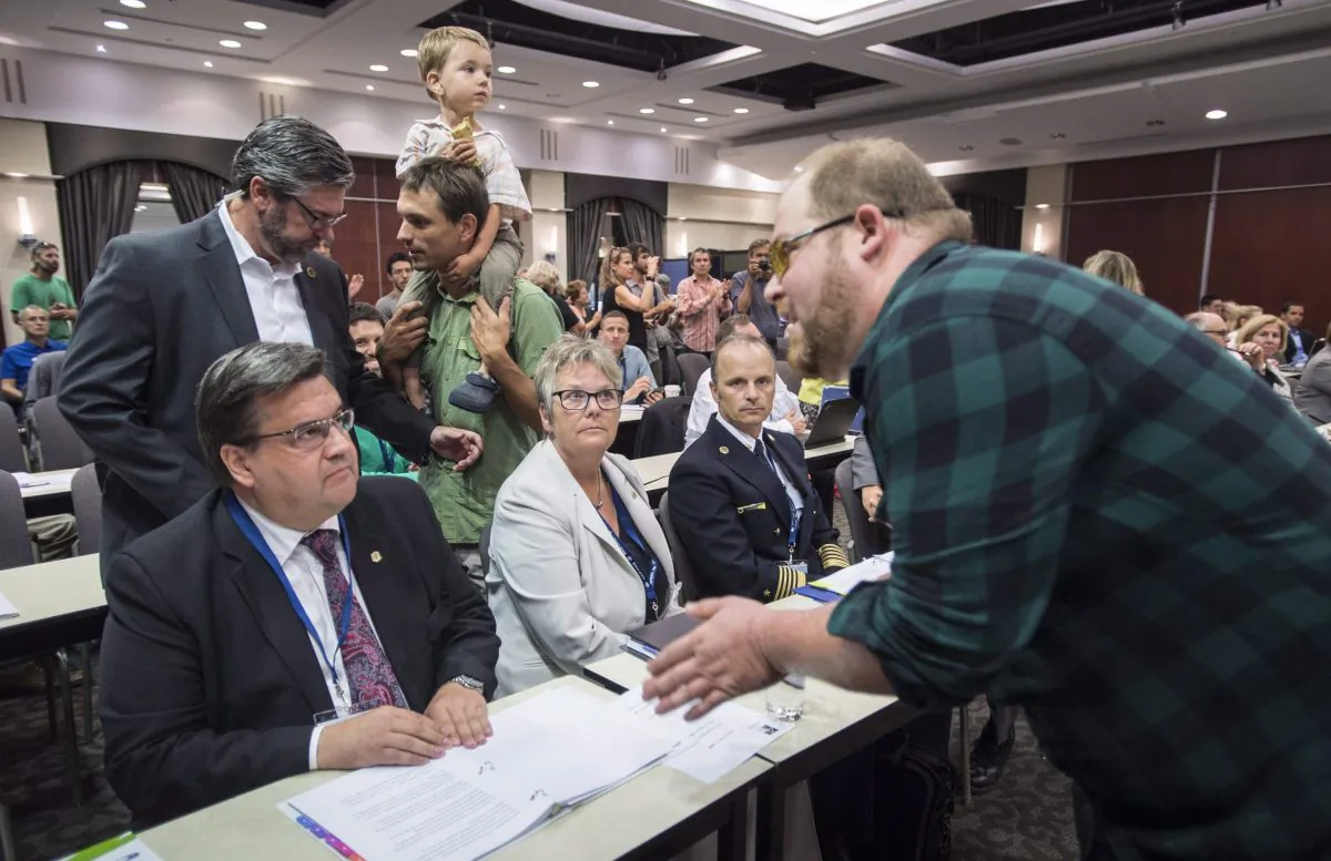A demonstrator confronts Montreal mayor Denis Coderre during the National Energy Board public hearing into the proposed $15.7-billion Energy East pipeline project in Montreal on Aug. 29. (The Canadian Press/Paul Chiasson)